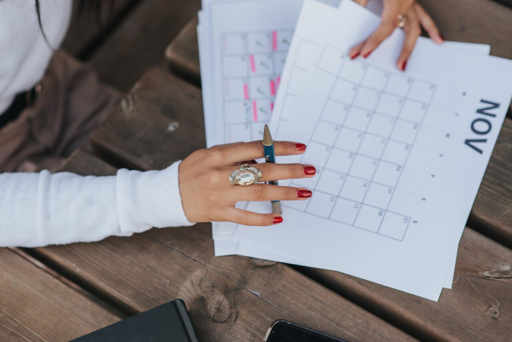 Photo d'une femme avec un calendrier pour illustrer la gestion d'une durée pour le challenge d'un mois sans rien dépenser.
