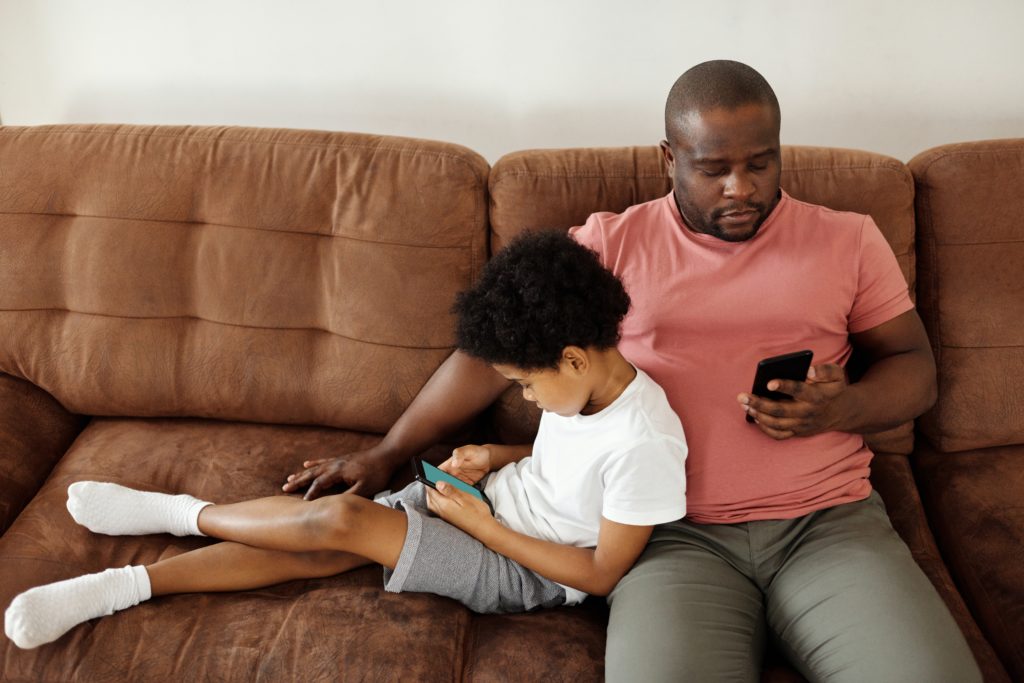 parent et enfant qui passent trop de temps devant les écrans, en besoin de désintoxication numérique