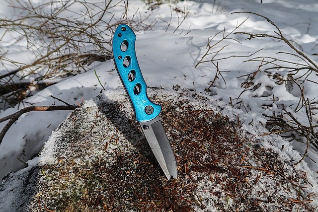 Couteau en acier inoxydable planté dans la neige. 