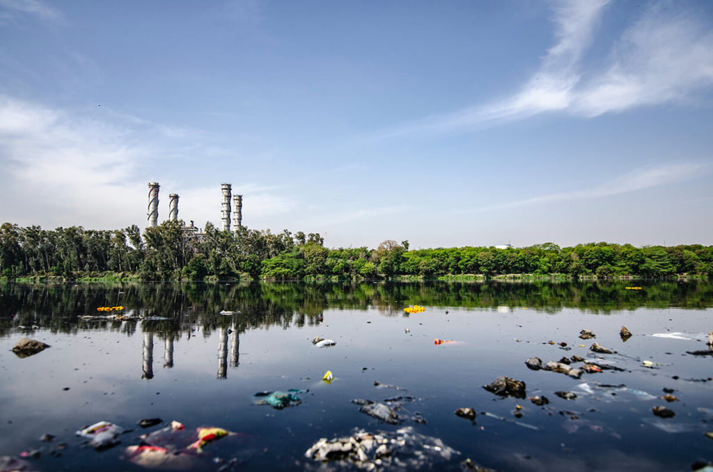 rivière jonchée d'ordure pour illustrer le greenwashing des société qui communiquent sur l'écologie mais sont en faite polluantes